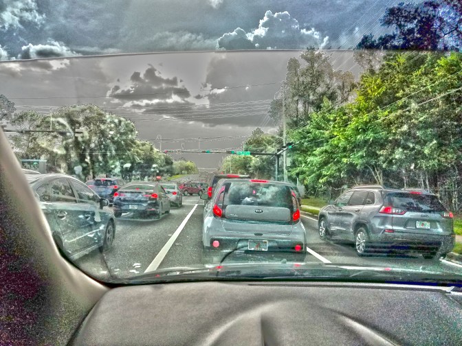 Multiple lanes of traffic bumper-to-bumper and unmoving, despite a green traffic indicator.