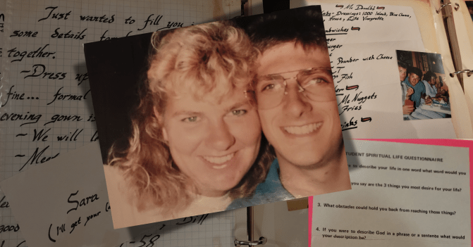a selfie of a smiling young man and woman against the backdrop of scrapbook pages