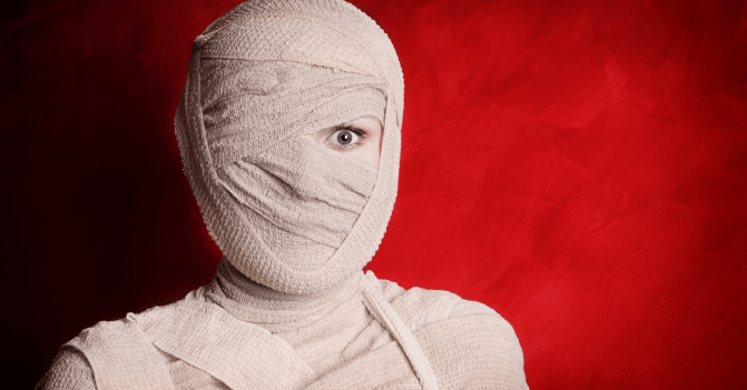 A woman wrapped like a mummy with one startled eye showing -- as a photo illustration