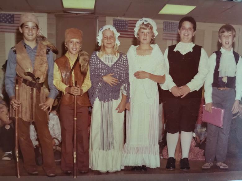 The image shows six fifth-grade students, dressed for a school musical celebrating our country's bicentennial in 1976.